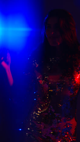 Vertical-Video-Of-Woman-In-Nightclub-Bar-Or-Disco-Dancing-With-Sparkling-Lights-In-Background